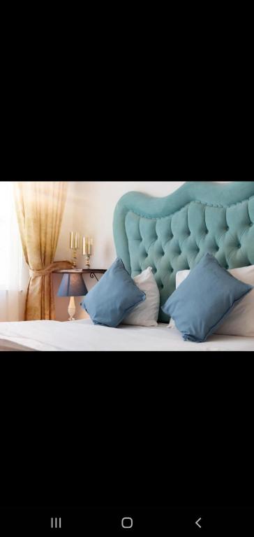 Bett mit blauem Kopfteil und Kissen in der Unterkunft 3 FLOOR OLD CITY 3 in Istanbul