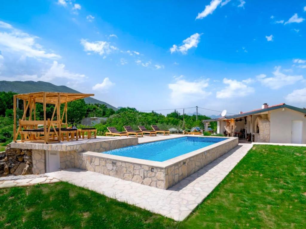 a backyard with a swimming pool and a grass yard at House Green Oaza in Zadvarje