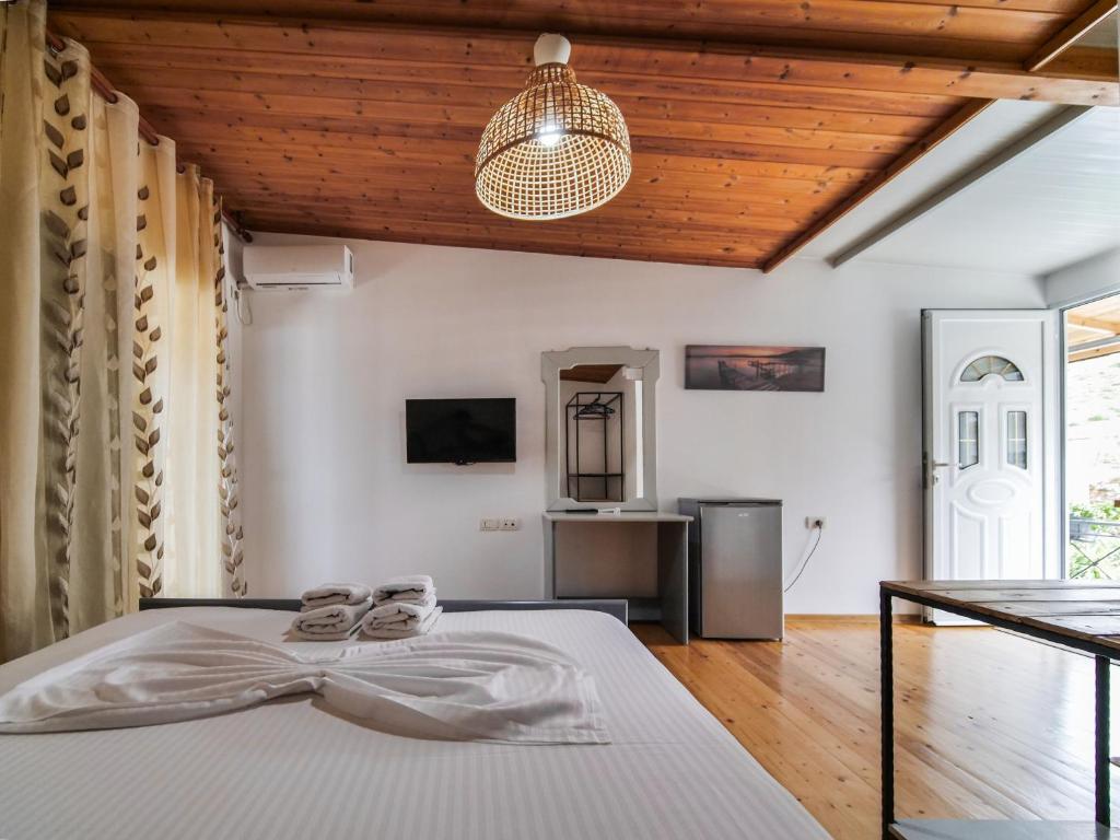 a bedroom with a bed and a pendant light at Sea Breeze Rooms in Himare