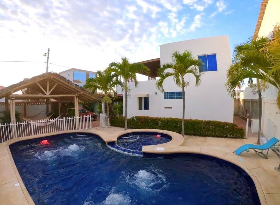 a large swimming pool in front of a house at Casa con piscina y salida a la playa in Playas