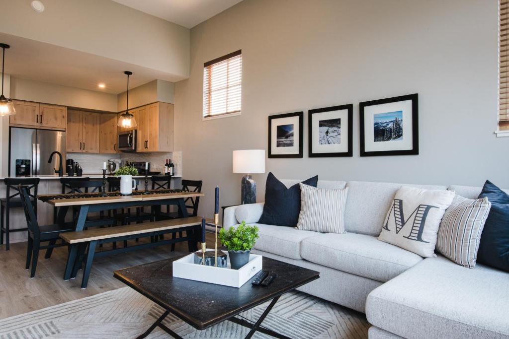 a living room with a couch and a table at New! Luxury, Top Floor, Ski in/Ski Out, Private Hot Tub and Mountain Views in Sun Peaks