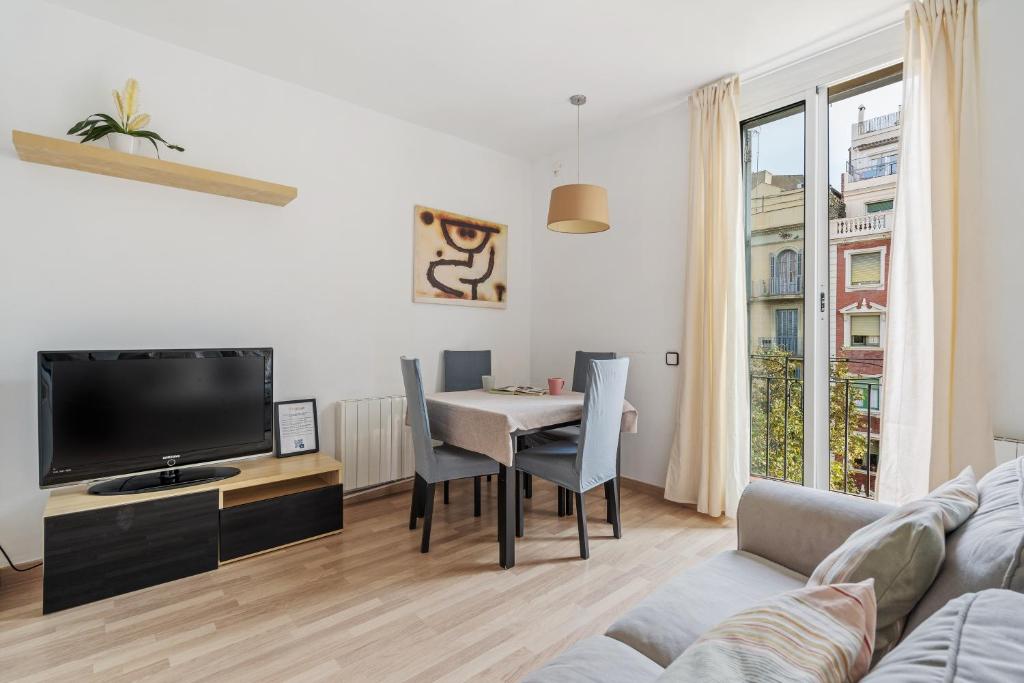 Sagrada Familia Avenida Gaudi Views&cozy Lounge في برشلونة: غرفة معيشة مع طاولة وتلفزيون