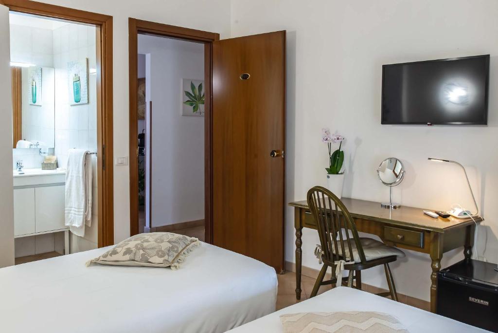 a bedroom with a desk and a bed and a desk with a computer at Plaza Rooms Ciampino in Ciampino