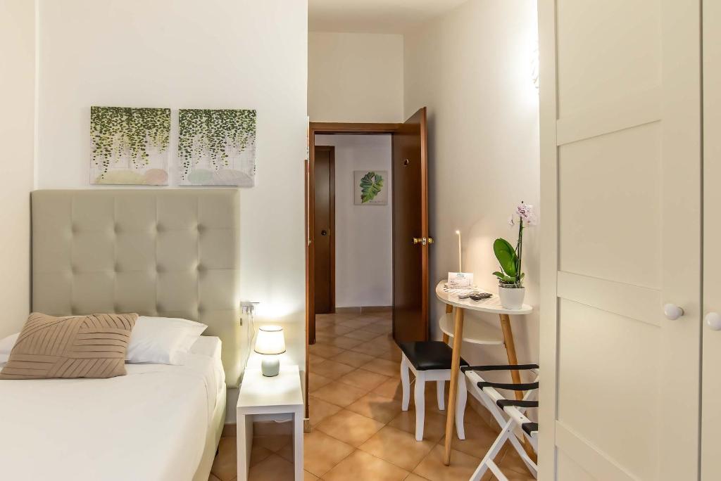 a bedroom with a bed and a table and a door at Plaza Rooms Ciampino in Ciampino