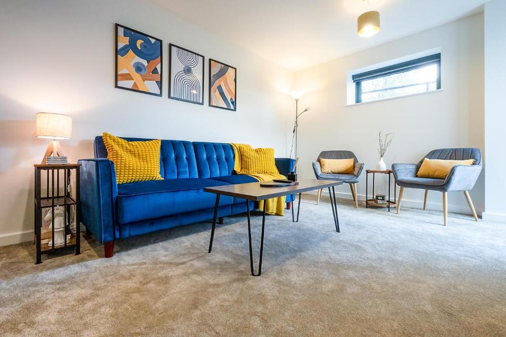 a living room with a blue couch and two chairs at Luton Modern Serviced Accommodation for contractors, relocators, professionals, tourists and students - AkuGi Homes in Luton