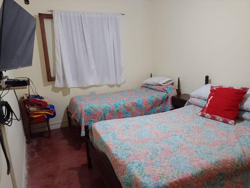 a room with two beds and a flat screen tv at La Posada de Ines in Yala