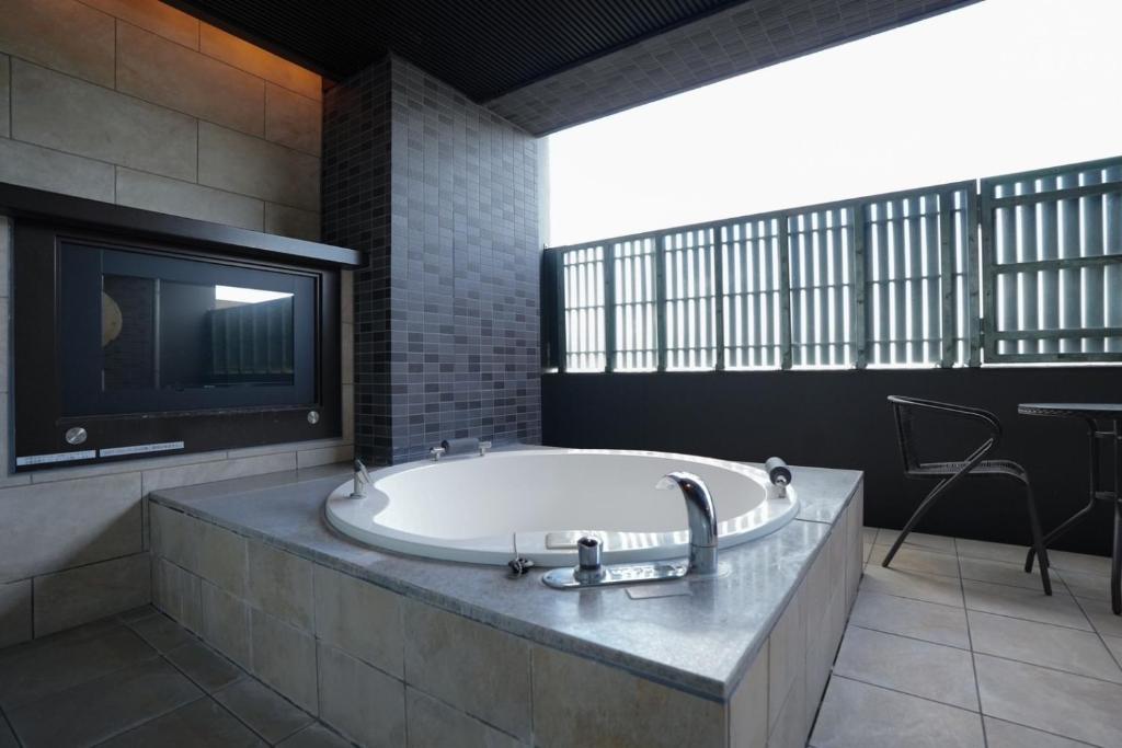 豊中市にあるHOTEL felice Osaka -伊丹空港-の広いバスルーム(バスタブ、テレビ付)