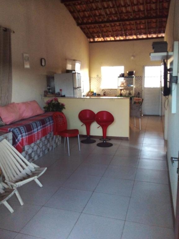 una cocina con 2 sillas rojas y una barra en Casa pé na areia ao lado de Mangue Seco, en Jandaíra