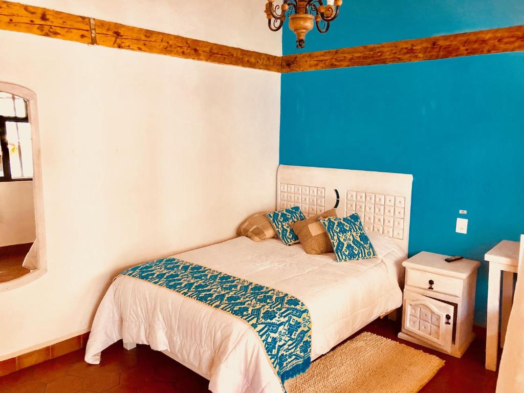 a bedroom with a bed with blue walls at Hotel Valle Bonito, Valle de Bravo in Valle de Bravo