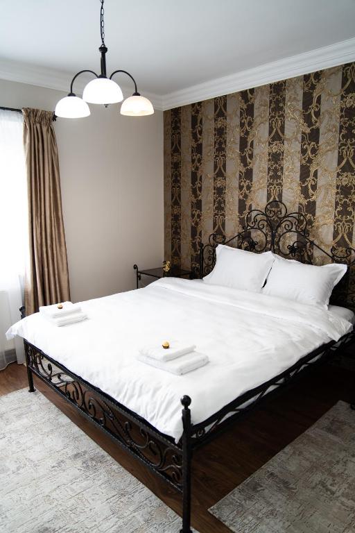 a bedroom with a large bed with white sheets at Central Parc Apartment 6 ! Self Check-in ! Free Parking ! WiFi in Suceava