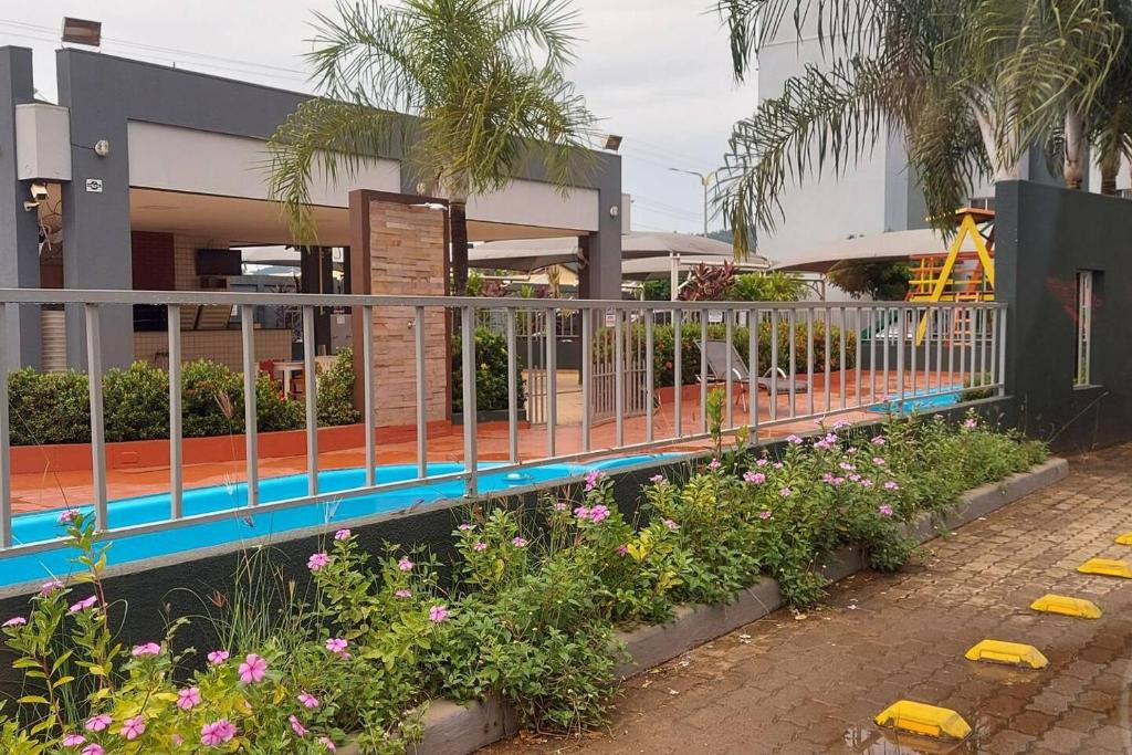 a fence in front of a building with flowers at Confortável apt em Parauapebas in Parauapebas