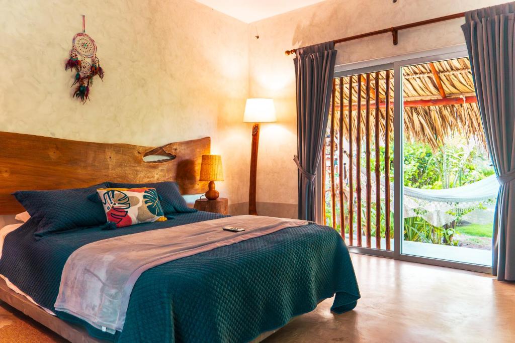 - une chambre avec un lit et une grande fenêtre dans l'établissement Ka´ana Surf, à El Paredón Buena Vista
