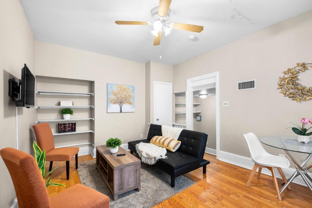 a living room with a black couch and a table at 1 Bdrm Modern Posh Upenndrexel Univ in Philadelphia