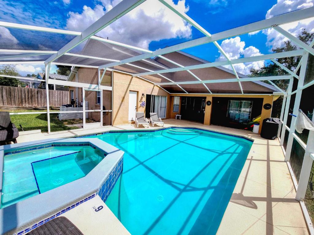 a swimming pool with a pergola and a swimming poolvisor at Serhii Villa Orlando - Heated Pool, Spa, Game Room - close to Disney in Davenport