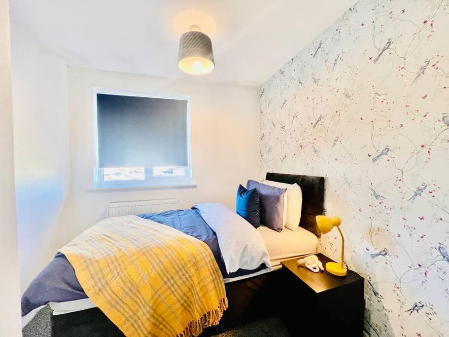 1 dormitorio con 1 cama y 1 mesa con lámpara en Canvey Island Bliss By Artisan Stays I Free Parking I Sleeps 5 I Relocation or Business, en Canvey Island