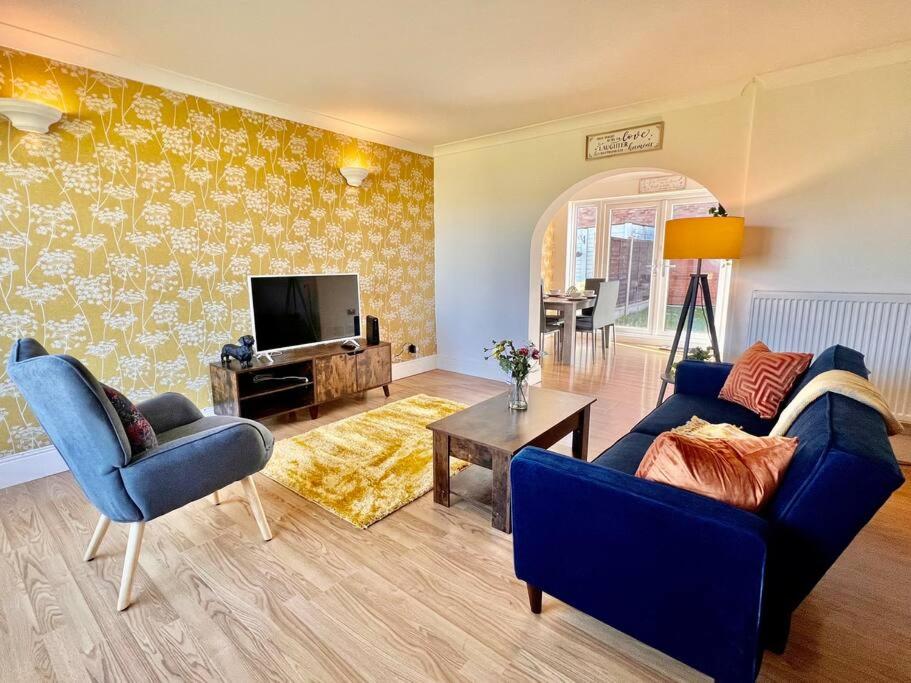 a living room with a blue couch and a tv at Canvey Island Bliss By Artisan Stays I Free Parking I Long Weekend Offer in Canvey Island