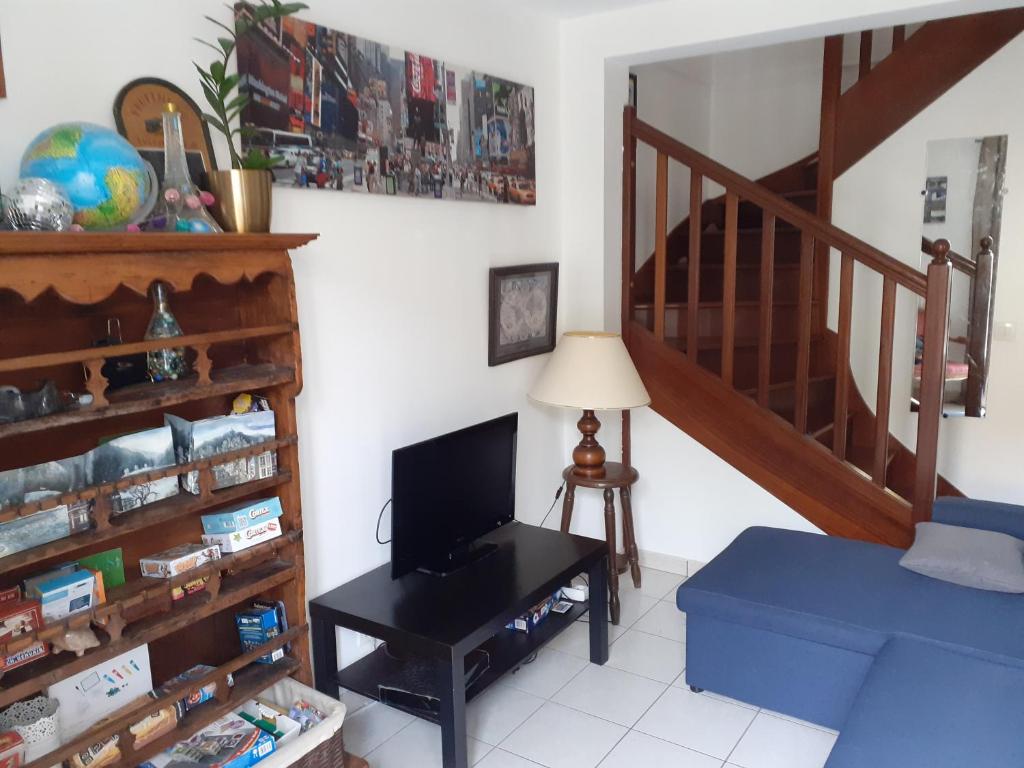 Maison 3 chambres avec jardinet في Ris-Orangis: غرفة معيشة بها درج وأريكة زرقاء