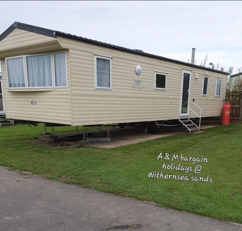 a beige house is parked in a yard at AM bargain holidays at Withernsea sands in Withernsea