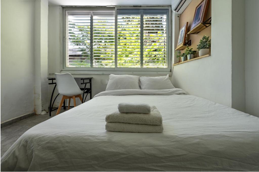 1 dormitorio con 1 cama con 2 toallas en Studio 91 By IsrApart, en Ramat Gan