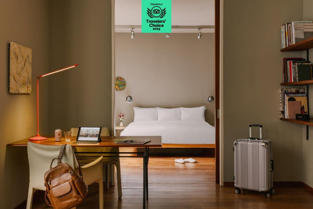 um quarto com uma cama e uma secretária com uma mala em Chambers powered by Sonder em Nova York