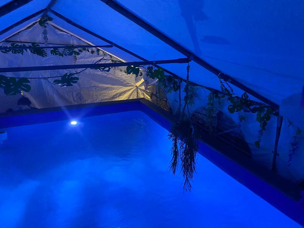 una casa con tienda y piscina por la noche en Mini Love Island style guest house with a hot private swimming pool and heated dining pod, secretly located in the busy suburbs of Nottingham, en Nottingham