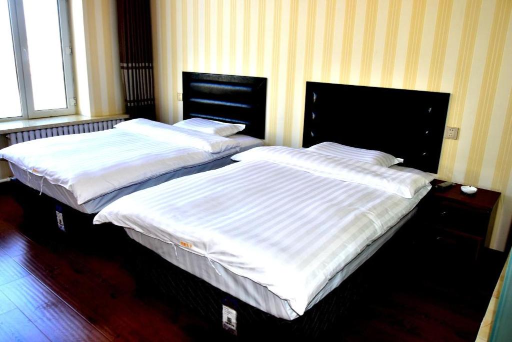 Postel nebo postele na pokoji v ubytování Harbin Binpeng Inn - Harbin Taiping International Airport