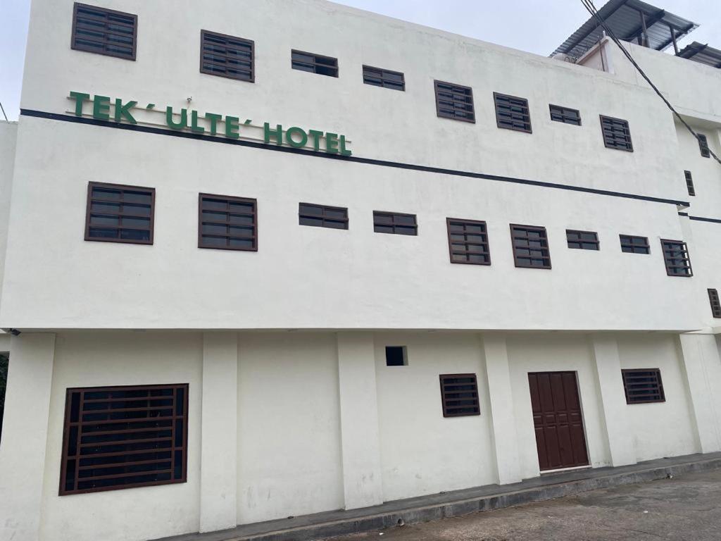 Hotel Magnolia Tek Ulte´ في كوميتان د دومينغوز: مبنى أبيض مع علامة تنص على أنه هذا الشق