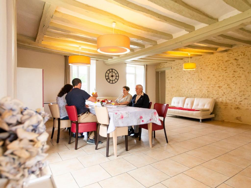 a group of people sitting at a table in a room at Gîte Saint-Christophe-en-Champagne, 5 pièces, 8 personnes - FR-1-410-192 in Saint-Christophe-en-Champagne