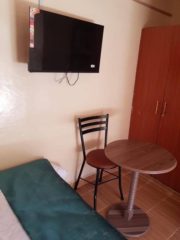 a room with a table and a chair and a tv at Hakuna matata Airbnb in Machakos