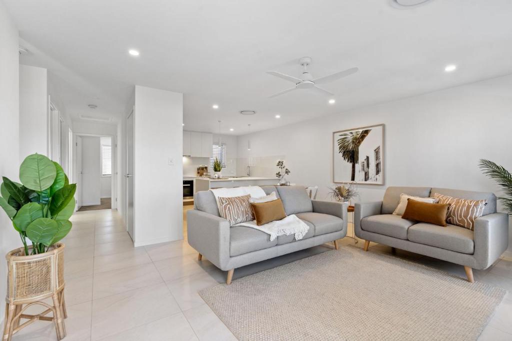 a living room with two chairs and a couch at Casa Allura in Coolum Beach