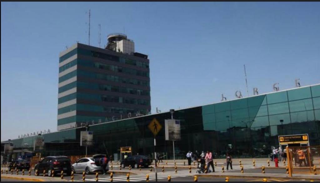 un gran edificio de cristal con coches aparcados en un aparcamiento en Casa sabina 2, en Lima