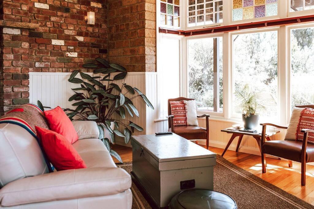 a living room with a couch and a brick wall at Tillrander - Scamander Retreat in Scamander