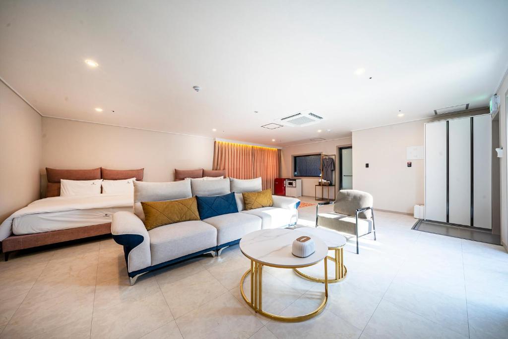 a bedroom with a bed and a couch and a table at Cherryblossom in Changwon