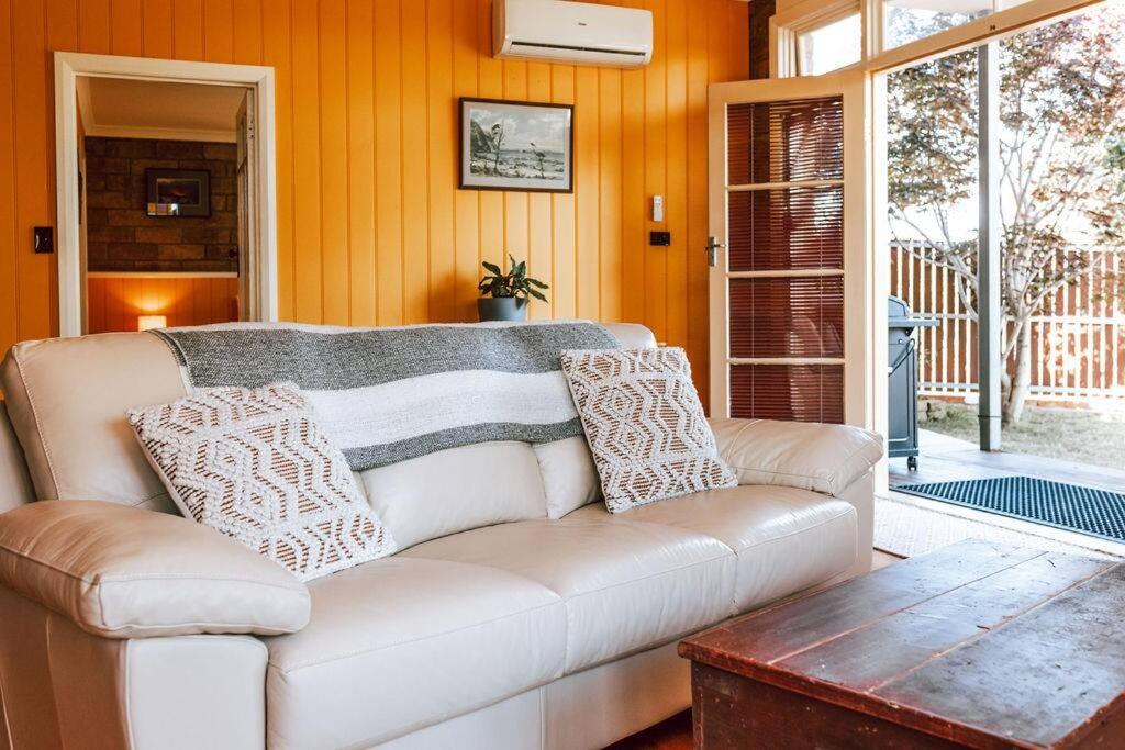 a living room with a white couch and a table at The most beautiful guest retreat in Scamander