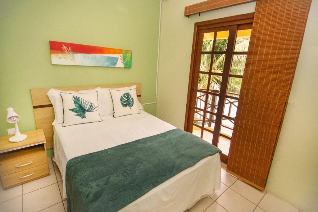 1 dormitorio con cama y ventana en Apartamentos Villa Porto do Sol, en Bombinhas