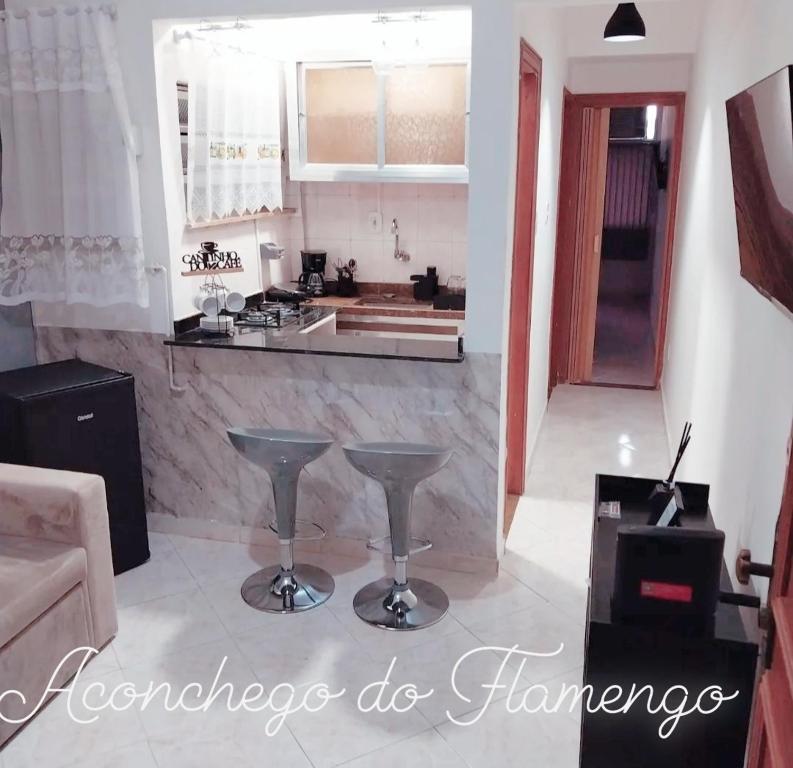 uma cozinha com um balcão e bancos num quarto em Aconchego do Flamengo no Rio de Janeiro