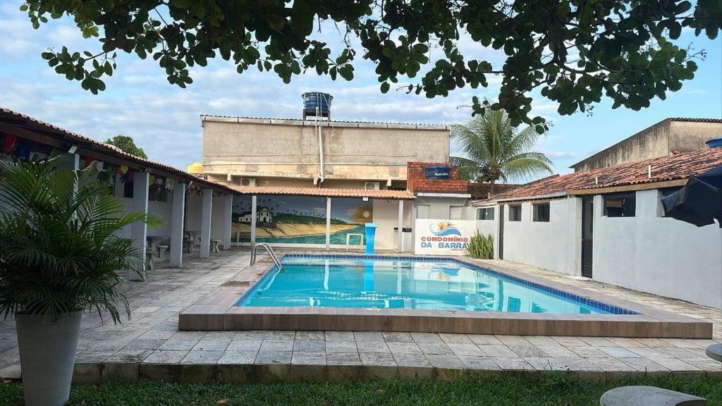 a swimming pool in front of a building at Condomínio da Barra - Chalé 6B in Tamandaré