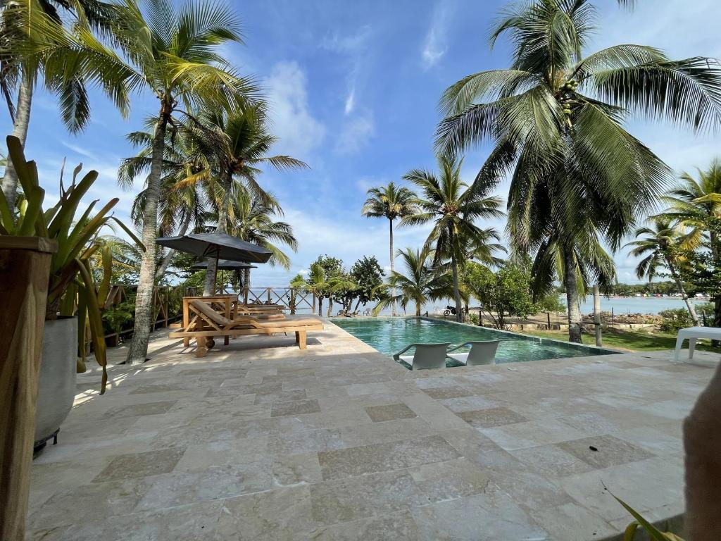 een zwembad met een bank en palmbomen bij Tubará Casa de Playa in San Antero