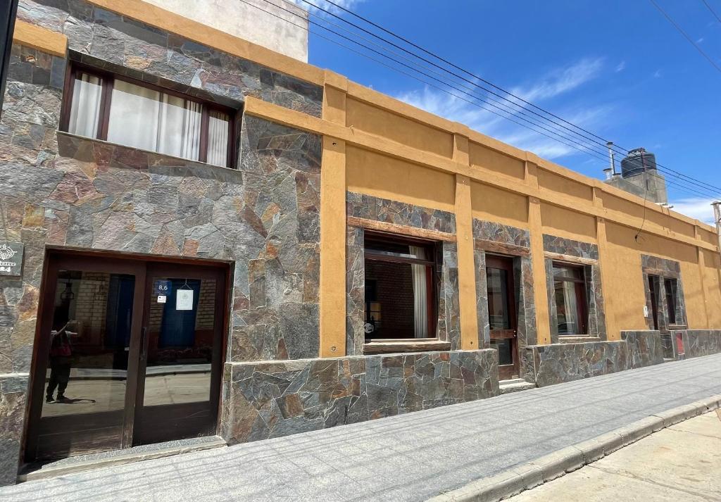 a stone building with doors and windows on a street at Refugio del Sol Hosteria in La Quiaca