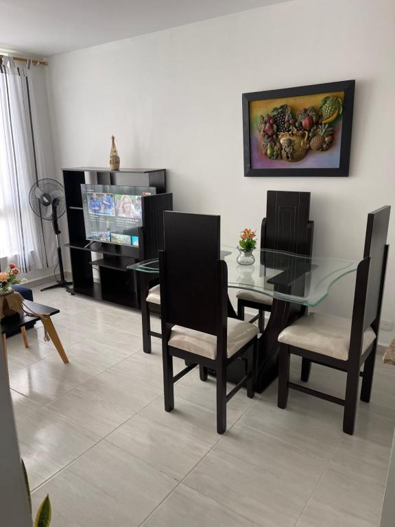 ein Esszimmer mit einem Glastisch und Stühlen in der Unterkunft Apartamento Santafe cartago V in Marinita