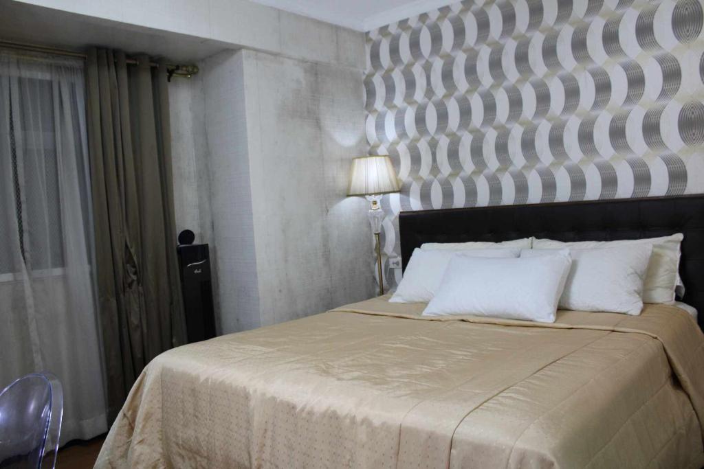 ein Schlafzimmer mit einem großen Bett mit einem großen Kopfteil in der Unterkunft Kaias Transient & Condotels - 539 Albergo in Baguio City