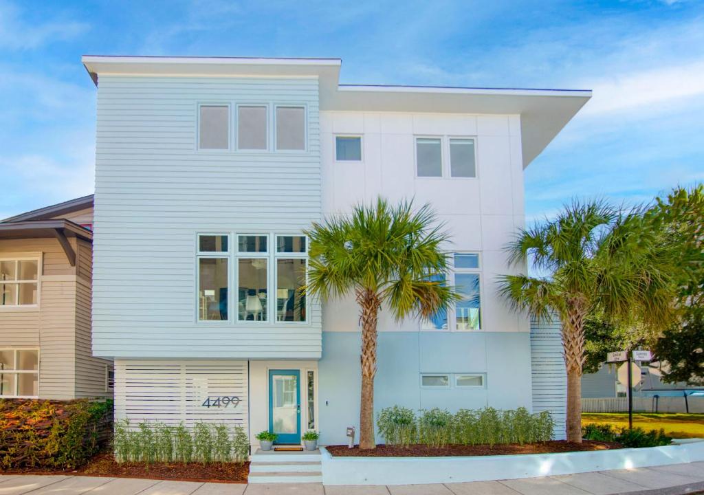 una casa blanca con palmeras delante en Happy Stays Mins to Park Circle Dtwn CHS Beach, en Charleston