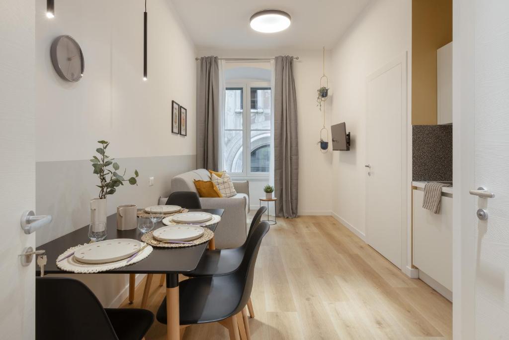 comedor y sala de estar con mesa y sillas en Trieste Timeless 2-bedrooms flat, en Trieste