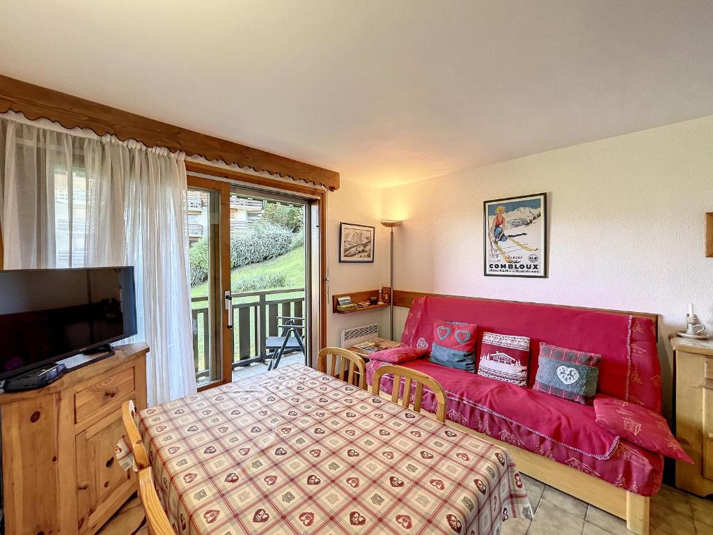 un salon avec un canapé rouge et une télévision dans l'établissement Studio cabine proche centre Combloux, 4 pers, balcon, parking - FR-1-560-53, à Combloux