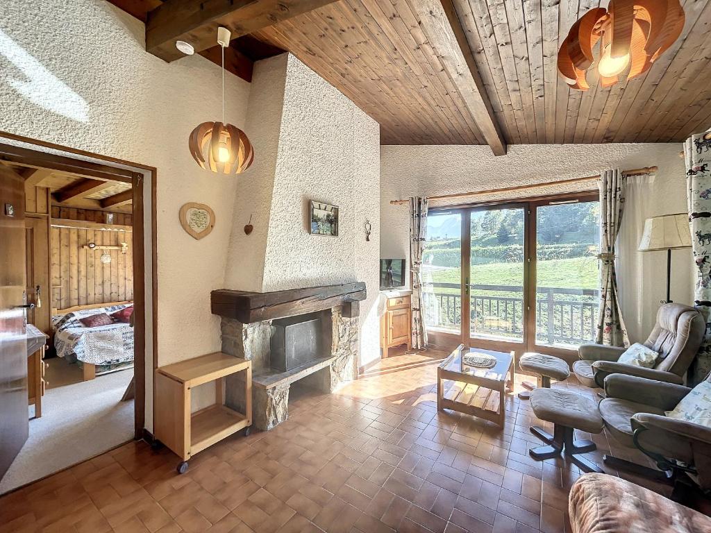 un salon avec un canapé et une cheminée dans l'établissement 2 Pièces + Mezzanine au pied des pistes avec Parking - Combloux - FR-1-560-64, à Combloux