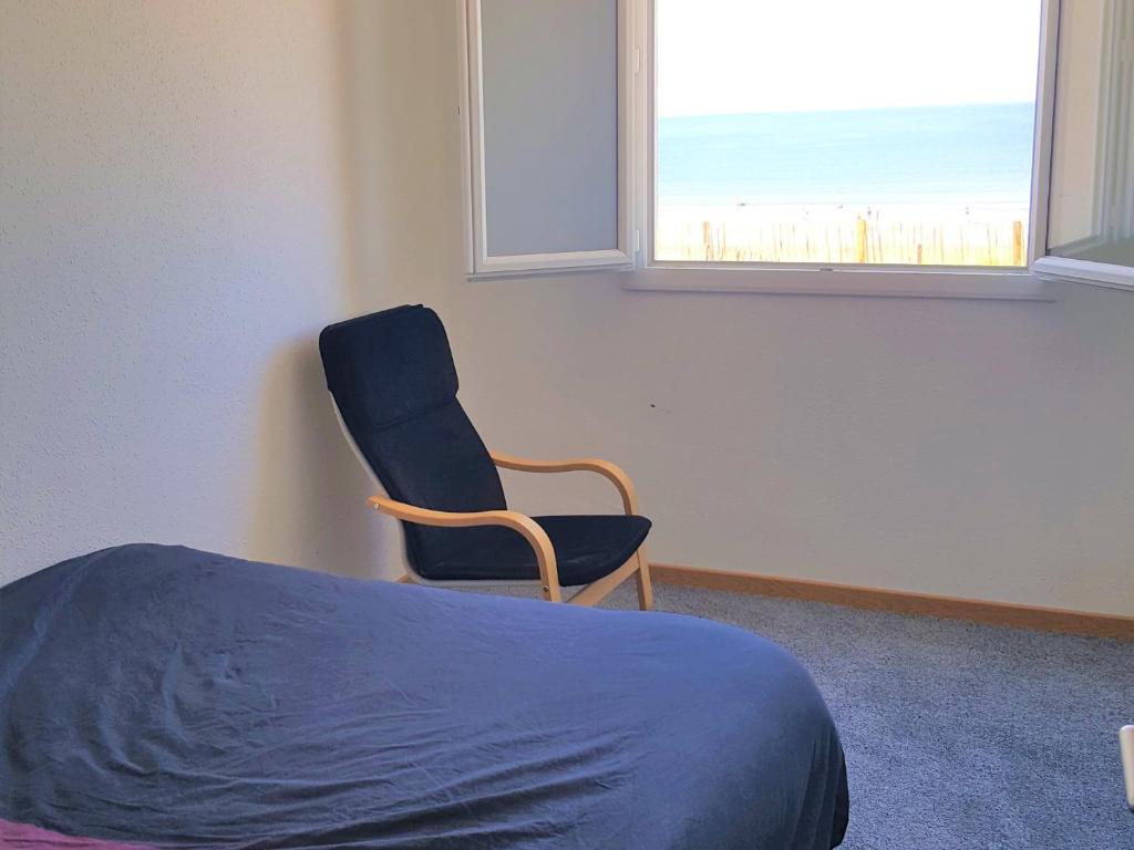 a bedroom with a chair and a bed and a window at Appartement Saint-Hilaire-de-Riez, 3 pièces, 6 personnes - FR-1-652-24 in Saint-Hilaire-de-Riez
