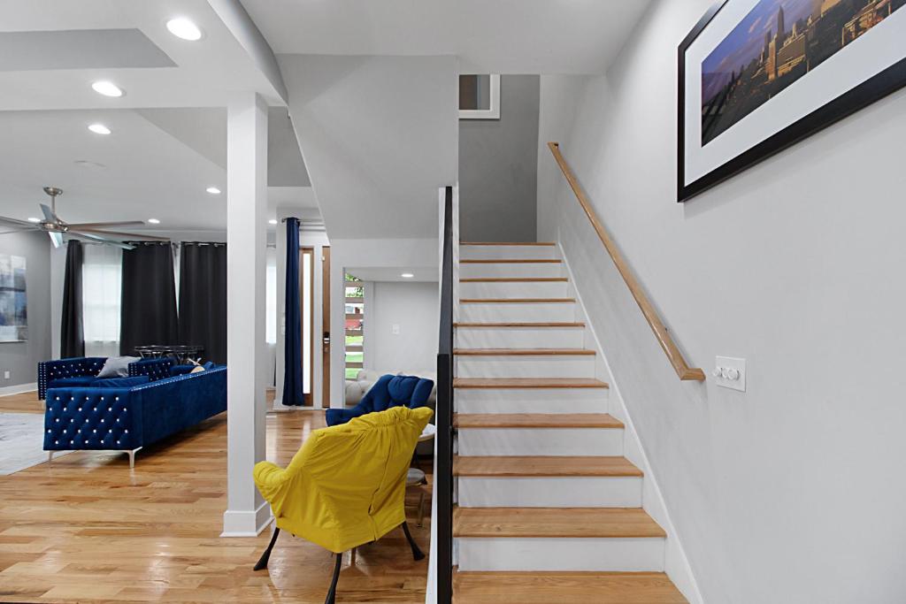 uma escada numa sala de estar com uma cadeira amarela em 2475-Upscale Luxury-5BR Mini Mansion Oasis em Decatur