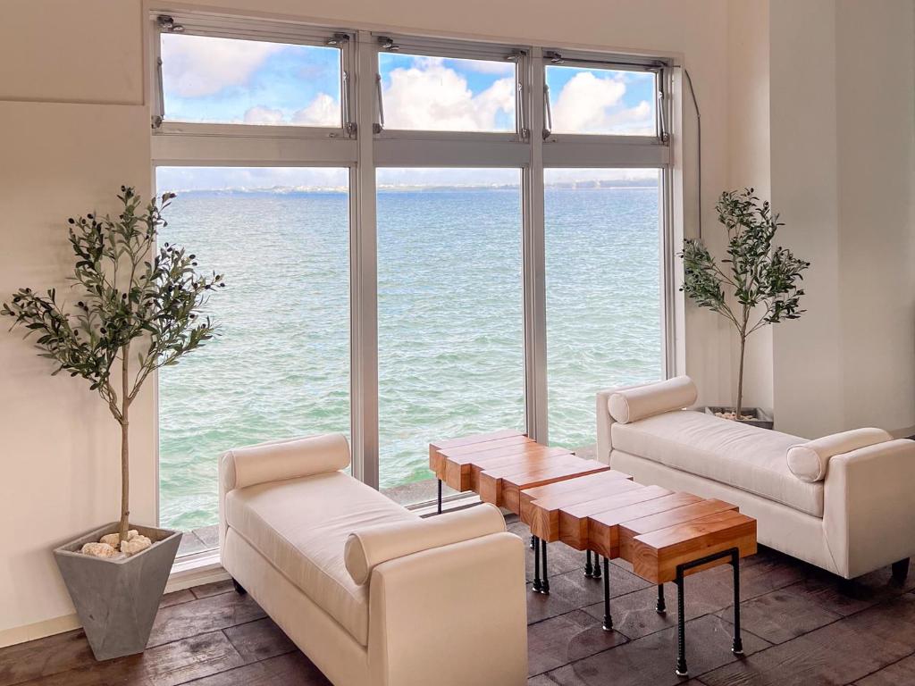 a living room with a table and chairs and a large window at マイビーチリゾート in Kin