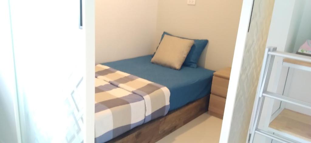 a small bedroom with a blue bed with a pillow at วิวสระว่ายน้ำและทะเลสาบ 3ห้องนอน 2ห้องน้ำ in Ban Tha Fat