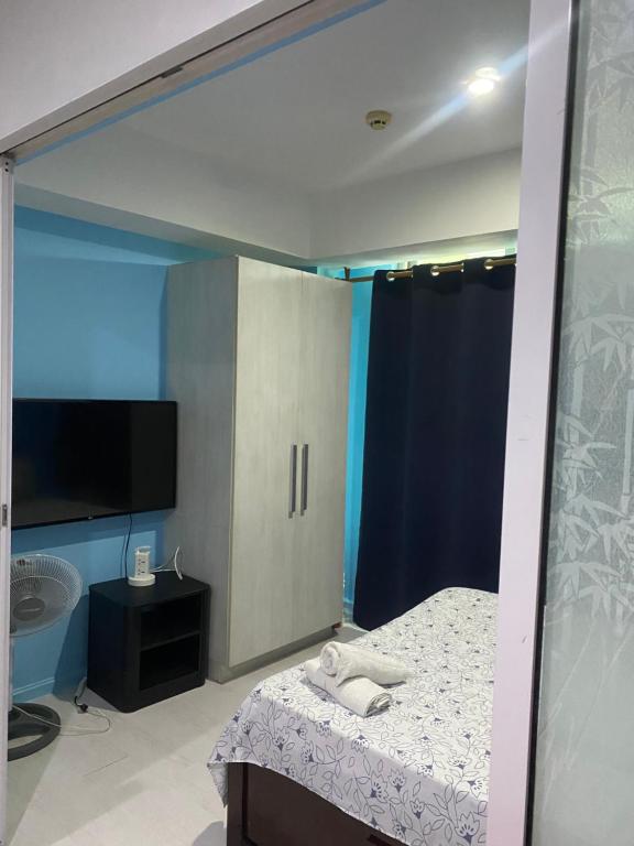 een slaapkamer met een bed en een badkamer met een tv bij Azure Urban Suite Room in Manilla